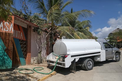 A tanker truck delivers potable water to a small tourist hotel.