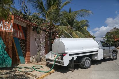 A tanker truck delivers potable water to a small tourist hotel.