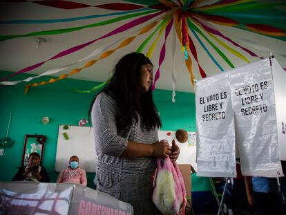 Una mujer junto a una casilla de votación en el municipio de Temoaya, en el Estado de México