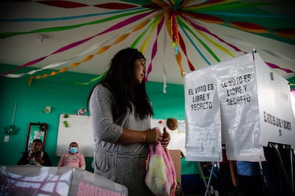 Una mujer junto a una casilla de votación en el municipio de Temoaya, en el Estado de México
