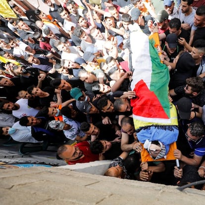 SENSITIVE MATERIAL. THIS IMAGE MAY OFFEND OR DISTURB Mourners carry the body of Palestinian man Hussien al-Titi, who was killed during stone-throwing clashes with Israeli forces, at Fawwar refugee camp near Hebron, in the Israeli-occupied West Bank, May 12, 2021. REUTERS/Mussa Qawasma