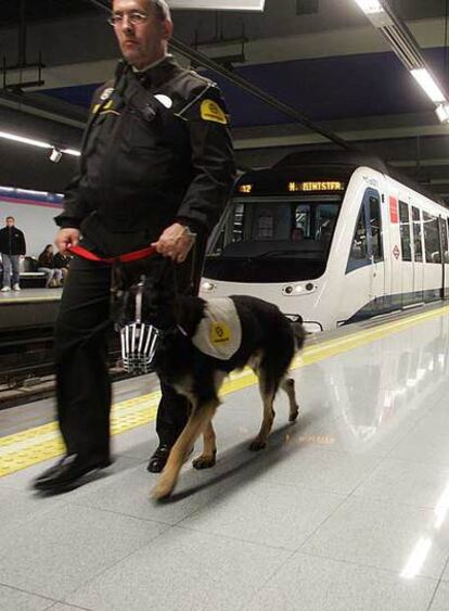 Un guardia de seguridad con un perro en el metro.