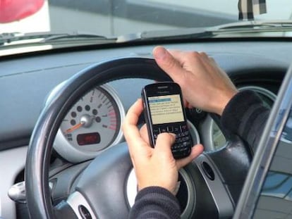 Un conductor utiliza un tel&eacute;fono m&oacute;vil durante la conducci&oacute;n.