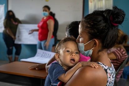 Glenda Xiomara atiende una clase con su hijo pequeño en brazos. Como madre soltera no tiene nadie quien lo cuide y se lo lleva a la escuela, donde lo atiende mientras toma los talleres.