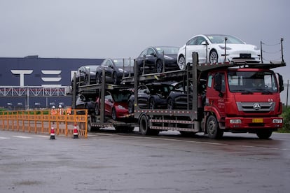 A truck transports new Tesla cars at its factory in Shanghai, China May 13, 2021.