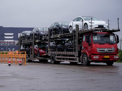 A truck transports new Tesla cars at its factory in Shanghai, China May 13, 2021.