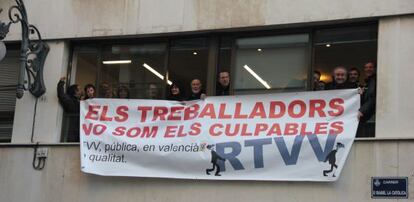 Miembros del comité de empresa que se han encerrado en RTVV exhiben una pancarta contra los recortes.