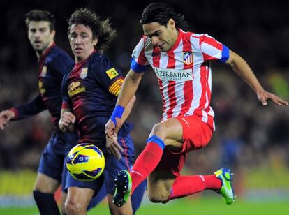 Falcao controla un balón ante Piqué y Puyol.