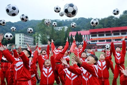 Estudiantes de primaria realizan un entrenamiento de fútbol en el patio de recreo, en Shangrao, provincia de Jiangxi (China). 
