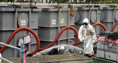 Un trabajador con ropa protectora, alrededor de los tanques de agua en la central de Fukushima. 
