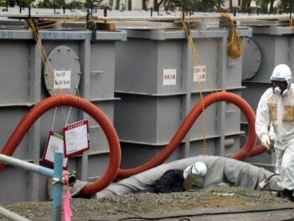 Un trabajador con ropa protectora, alrededor de los tanques de agua en la central de Fukushima.