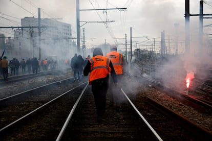 Un grupo de trabajadores camina entre las vías del tren en París, este martes.
