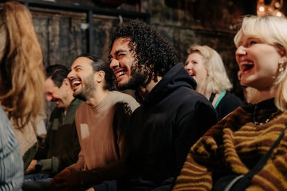Un grupo de gente riéndose durante un monólogo de humor.