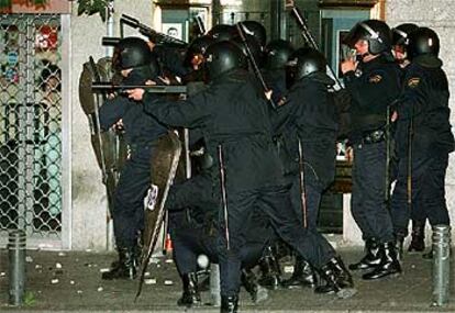 Un grupo de policías se prepara para disparar pelotas de goma a los manifestantes que han ocasionado los disturbios.