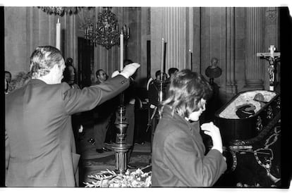 Un hombre hace el saludo fascista ante el cadáver de Francisco Franco, mientras una mujer se persigna ante el catafalco. Miles de personas lo hicieron durante las 48 horas que permaneció abierta la capilla ardiente del dictador. La imagen es del 22 de noviembre de 1975.