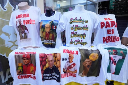 Camisetas con imágenes del recién elegido Papa León XIV y referencias a su paso por Perú se exponen para su venta en Limajia)