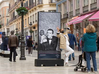 Una mujer se fotografía junto a una imagen de Antonio Banderas en calle Larios, en Málaga.