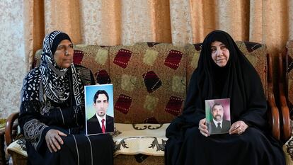 Nidal Ali, right, and Nawal Sweidan hold photos of their missing sons in Mahmoudiya, south of Baghdad, Iraq, Tuesday, March 28, 2023.