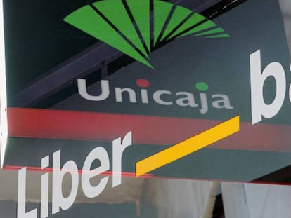 Logotipos de Unicaja y Liberbank en el exterior de sendas sucursales bancarias.