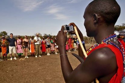 Un joven masai toma una foto a un grupo de turistas. 