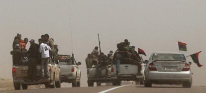 Rebeldes libios huyen después de que las tropas de Gadafi bombardearan su posición en Al Ugaila.