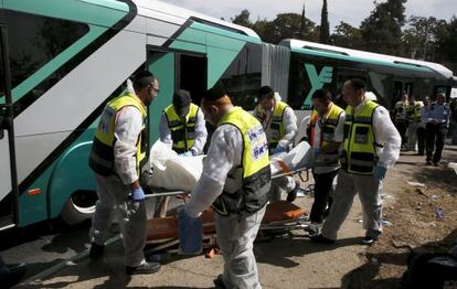 Treballadors sanitaris transporten el cos d'una víctima mortal en l'atac en un autobús a Jerusalem Est.