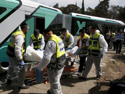 Treballadors sanitaris transporten el cos d'una víctima mortal en l'atac en un autobús a Jerusalem Est.