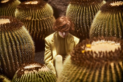 Oasis de color. En el Jardín de Cactus, Manrique respetó los monolitos volcánicos y la escasa vegetación de la zona. El resultado es una mezcla explosiva de negro, verde y azul, inédita en la naturaleza. Blazer (779 €), cárdigan (555 €.), jersey (259 €), falda (285 €) y medias (22 €), todo de MAX MARA.