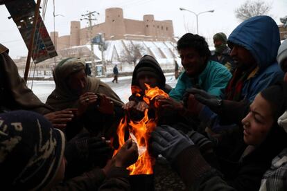 Afganos se reúnen alrededor del fuego para combatir las frías temperaturas en Herat (Afganistán).