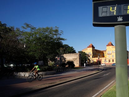 Un ciclista pasa junto a un termómetro que marca 41 grados a última hora de la tarde este jueves, en Córdoba.