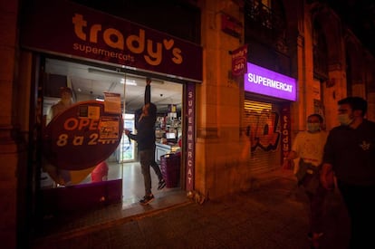 Un supermercat 24 hores davant de l'estació de França abaixa la persiana a les 10 de la nit.