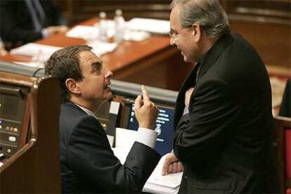 José Luis Rodríguez Zapatero, sentado, charla con Alfonso Guerra, presidente de la Comisión Constitucional.