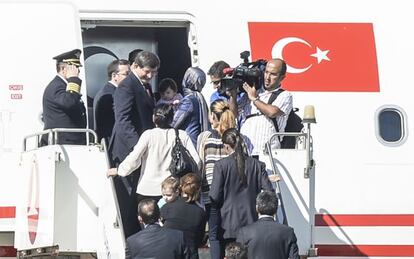 O primeiro-ministro turco, Ahmed Davutoglu (acima à esquerda), recebe os reféns libertados, em um avião em Sanliurfa.