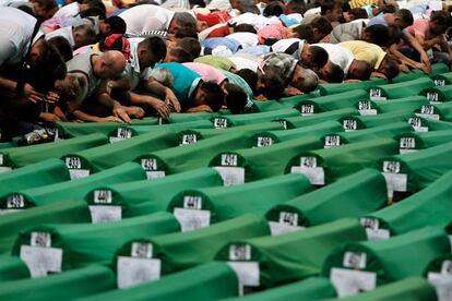 Familiares de las víctimas rezan frente a los 613 ataúdes en el cementerio de Potocari.