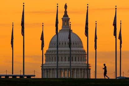 FILE - The U.S. Capitol Building looms behind flags on the National Mall in Washington Nov. 7, 2022. Fitch Ratings has downgraded the United States government's credit rating, citing rising debt at the federal, state, and local levels and a "steady deterioration in standards of governance" over the past two decades.(AP Photo/J. David Ake, File)