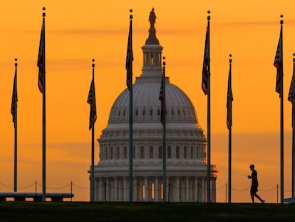 FILE - The U.S. Capitol Building looms behind flags on the National Mall in Washington Nov. 7, 2022. Fitch Ratings has downgraded the United States government's credit rating, citing rising debt at the federal, state, and local levels and a "steady deterioration in standards of governance" over the past two decades.(AP Photo/J. David Ake, File)