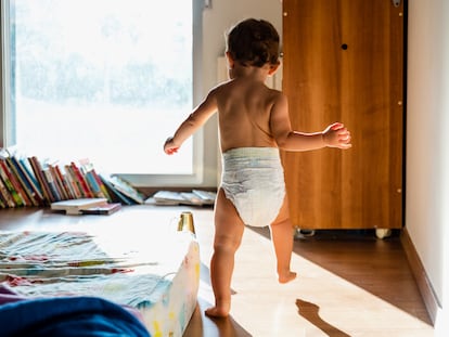 Un niño camina con su pañal puesto.