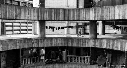 Una niña se pasea en bicicleta por un piso del bloque de la Torre de David.