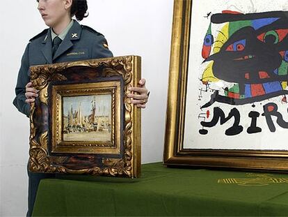 Una agente de la Guardia Civil sostiene el óleo falso de Édouard Manet delante del <i>miró</i> auténtico.