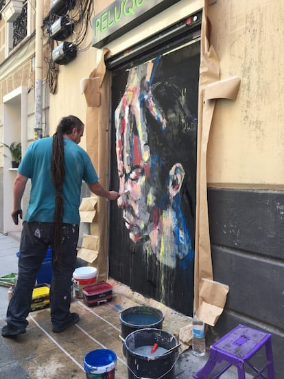El artista Casassola terminando 'Working class', su mural sobre la clase obrera que reina en Lavapiés.