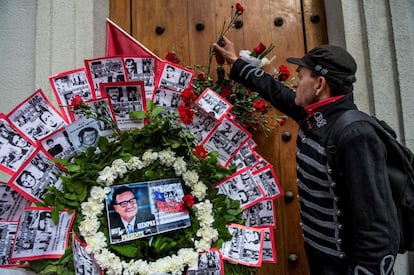 Homem coloca uma flor ao lado de uma coroa em homenagem ao falecido ex-presidente Salvador Allende durante uma manifestação diante do palácio presidencial La Moneda, em Santiago.