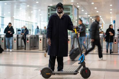 Kaou Baraji junto a su patinete eléctrico en la Estación de Sants (Barcelona).