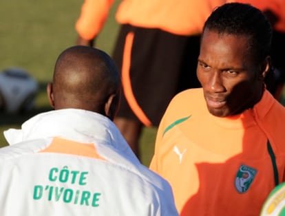 Didier Drogba habla con uno de los miembros del cuerpo técnico de la selección