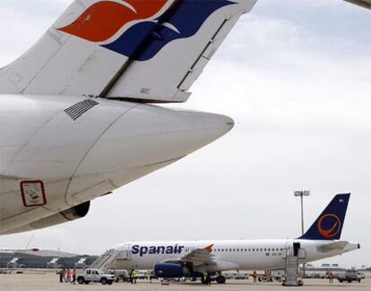 Un avión pintado con el logo de la nueva Spanair junto a uno decorado con el antiguo en El Prat.