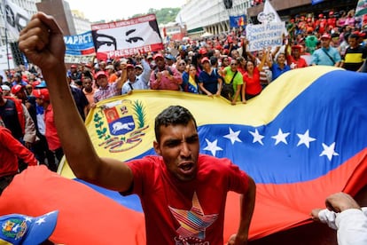 Seguidores de Nicolás Maduro portan una enorme bandera de Venezuela durante una manifestación a favor del presidente por Caracas (Venezuela).