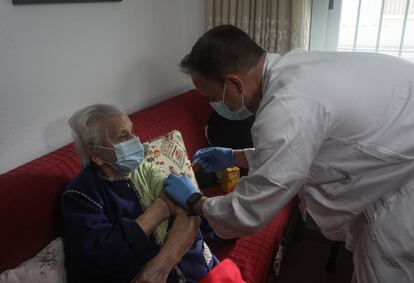 David le pone a Carmen la vacuna contra la bacteria del neumococo durante su visita médica.