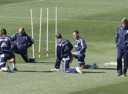 Bernd Schuster se pasea, absorto, junto a un grupo de jugadores durante el entrenamiento de ayer del Madrid.