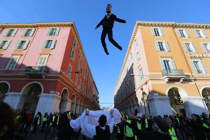 Os choques com a polícia em Bourges começaram na mesma hora que os de Paris, com a queima de parte do mobiliário urbano. Na imagem, manifestantes atiram para o ar um boneco que representa o presidente francês Macron, durante manifestação em Niza.