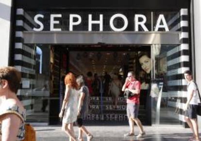 Viandantes pasean junto a una tienda de firma de cosmética en Madrid. EFE/Archivo