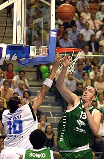 El pívot del Unicaja Weiss, a la derecha, y Sconochini, del Tau, pugnan por un balón.